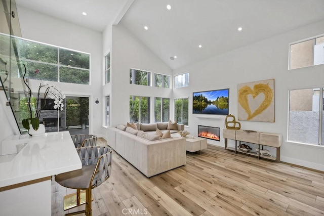 24523 Via Esquina, Calabasas, CA 91302 - living area with high vaulted ceiling, light wood-type flooring, a glass covered fireplace, and recessed lighting