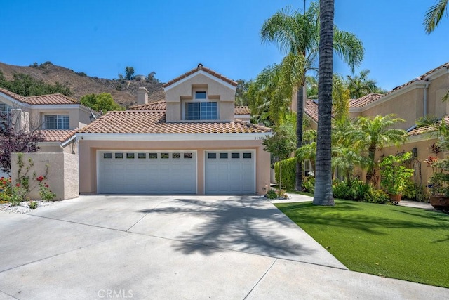 24523 Via Esquina, Calabasas, CA 91302 - mediterranean / spanish-style home with driveway, stucco siding, a tiled roof, a front lawn, and a garage