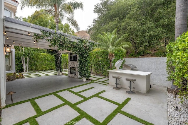 24523 Via Esquina, Calabasas, CA 91302 - view of patio / terrace featuring an outdoor stone fireplace, area for grilling, exterior bar, and a pergola