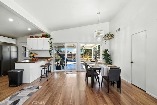 951 W Olive St, Corona, CA 92882 - dining area with light wood-style flooring, a chandelier, and high vaulted ceiling