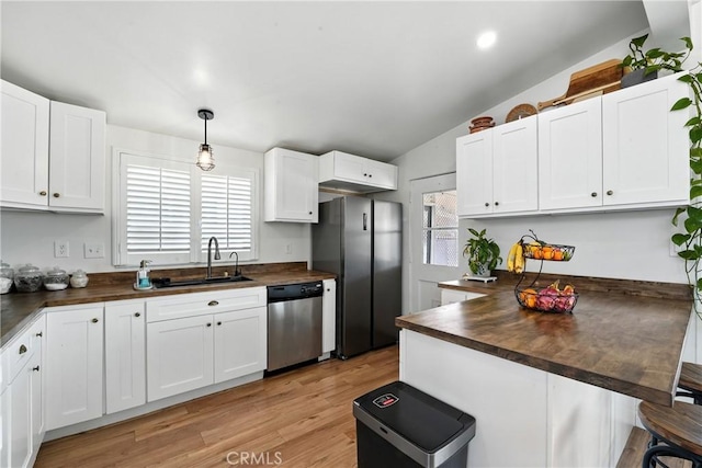 951 W Olive St, Corona, CA 92882 - kitchen featuring stainless steel appliances, wood counters, white cabinets, light wood-style floors, and a breakfast bar