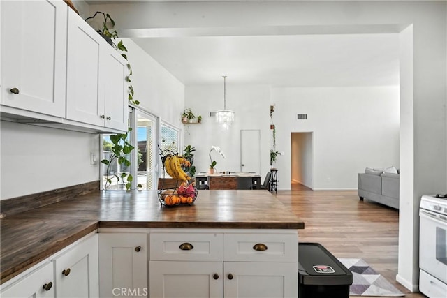 951 W Olive St, Corona, CA 92882 - kitchen featuring wood counters, gas range gas stove, white cabinets, a peninsula, and wood finished floors