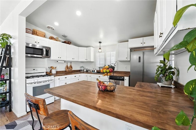 951 W Olive St, Corona, CA 92882 - kitchen featuring stainless steel appliances, wooden counters, white cabinets, wood finished floors, and vaulted ceiling