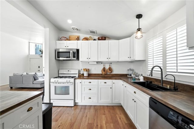 951 W Olive St, Corona, CA 92882 - kitchen with stainless steel appliances, butcher block counters, white cabinetry, pendant lighting, and lofted ceiling