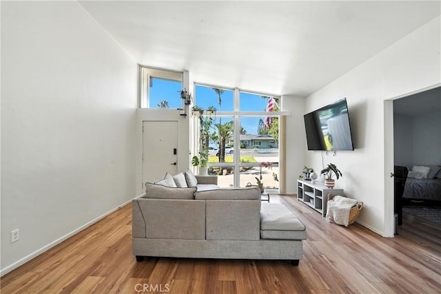 951 W Olive St, Corona, CA 92882 - living area with wood finished floors, vaulted ceiling, and a wall of windows