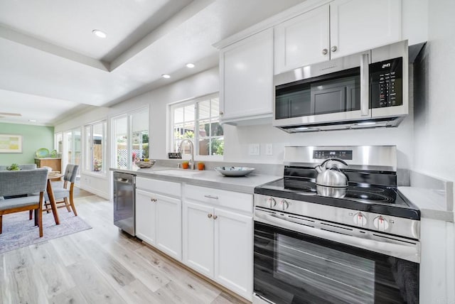 15020 Penasquitos Dr, Rancho Penasquitos, CA 92129 - kitchen with appliances with stainless steel finishes, light countertops, light wood-style floors, white cabinetry, and recessed lighting