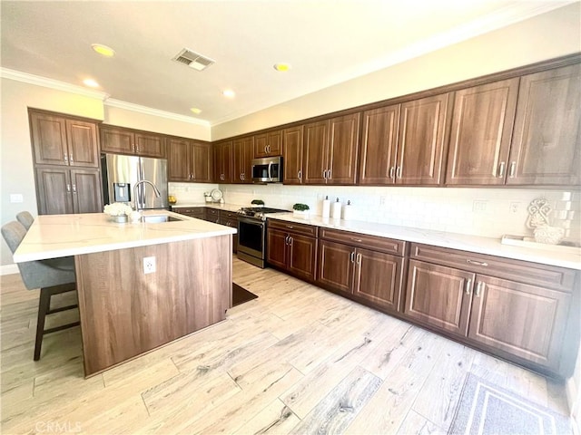 29 Spring View Way, Rancho Santa Margarita, CA 92688 - kitchen featuring stainless steel appliances, ornamental molding, light wood-style floors, a breakfast bar area, and backsplash