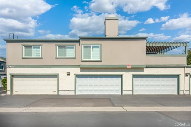 23640 Monument Canyon Dr Unit C, Diamond Bar, CA 91765 - view of property featuring an attached garage, a chimney, and stucco siding