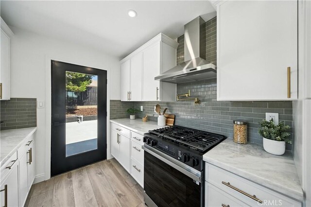 5243 Tara Pl, San Diego, CA 92117 - kitchen featuring wall chimney range hood, black gas range, white cabinetry, light wood-style floors, and backsplash