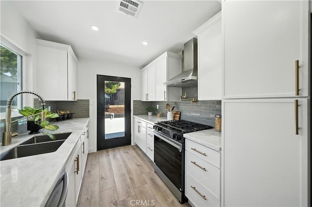 5243 Tara Pl, San Diego, CA 92117 - kitchen featuring gas stove, wall chimney exhaust hood, light wood-style flooring, white cabinets, and recessed lighting