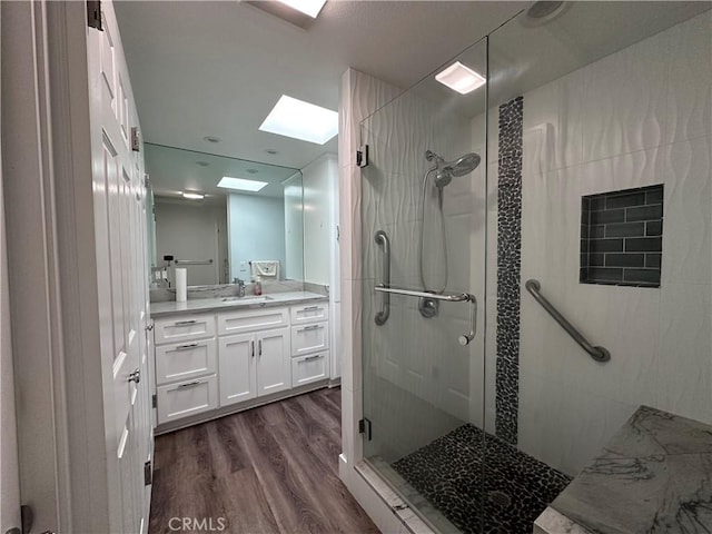 1501 Pelham Unit 127F, Seal Beach, CA 90740 - bathroom featuring a skylight, a stall shower, vanity, and wood finished floors