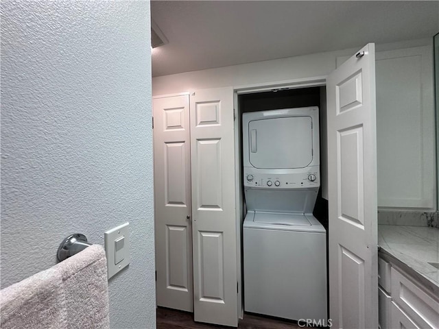 1501 Pelham Unit 127F, Seal Beach, CA 90740 - laundry area featuring stacked washer and clothes dryer and a textured wall