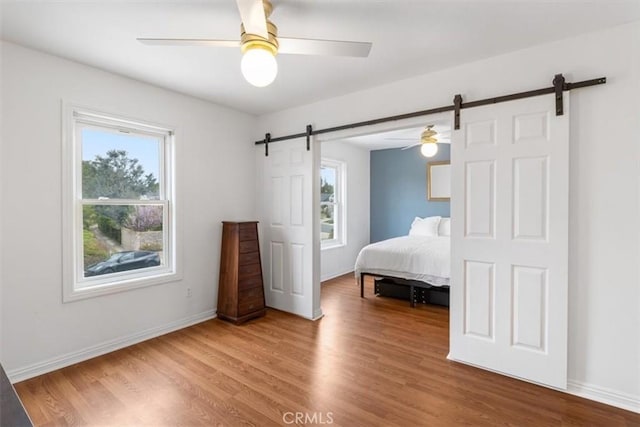 25912 Densmore Dr, Lake Forest, CA 92630 - bedroom featuring a barn door, multiple windows, wood finished floors, and a ceiling fan