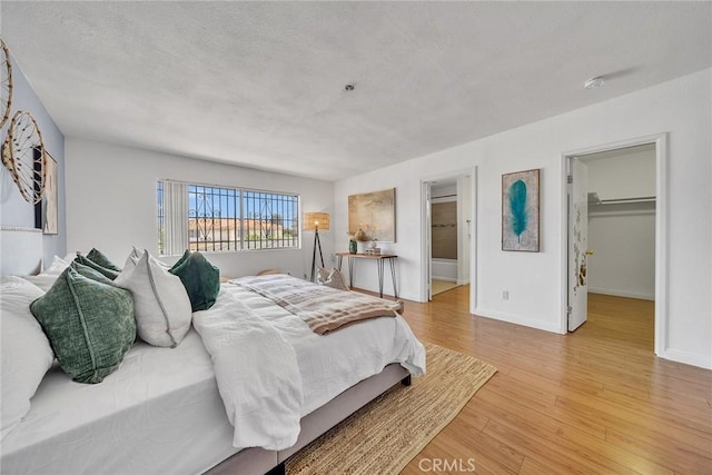 3687 Durfee Ave Unit 3, El Monte, CA 91732 - bedroom featuring light wood-style flooring, a spacious closet, a textured ceiling, and ensuite bath
