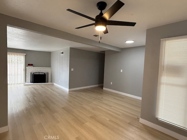 828 Ellen St, Colton, CA 92324 - unfurnished living room with light wood finished floors, a ceiling fan, and a fireplace