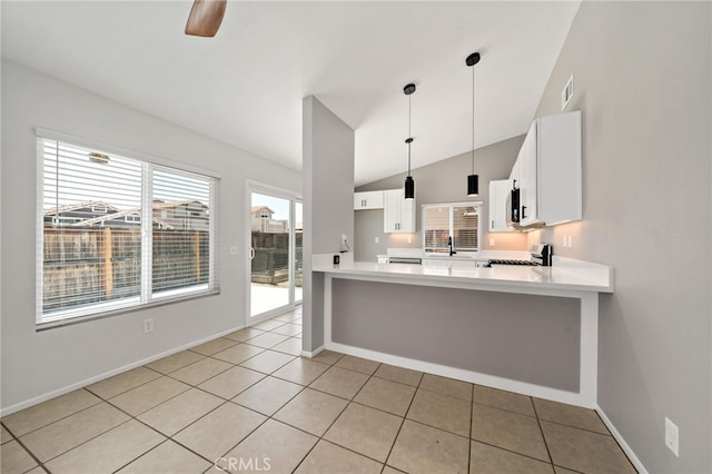25671 Roylene Dr, Menifee, CA 92586 - kitchen featuring stove, lofted ceiling, a peninsula, white cabinetry, and light countertops
