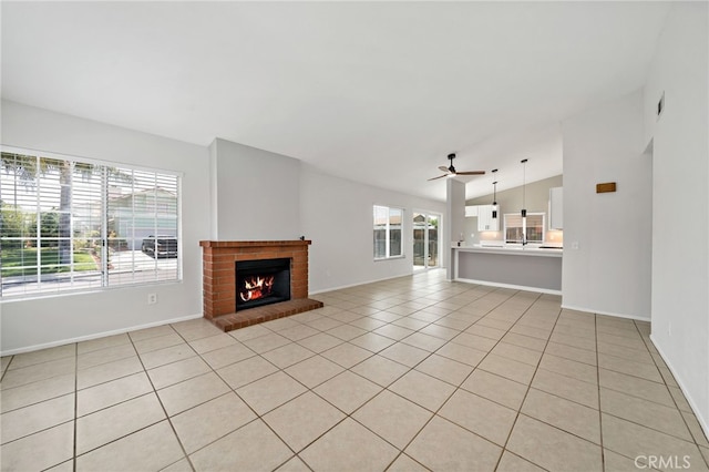 25671 Roylene Dr, Menifee, CA 92586 - unfurnished living room featuring lofted ceiling, a ceiling fan, light tile patterned flooring, and a brick fireplace