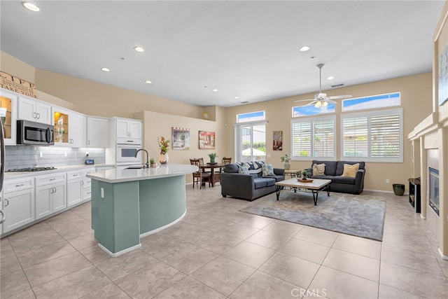 11567 Waterwell Ct, Riverside, CA 92505 - kitchen featuring stainless steel microwave, white oven, light countertops, white cabinets, and ceiling fan
