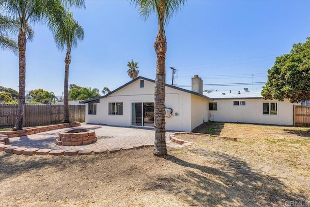 1327 Walbollen St, Spring Valley, CA 91977 - back of property featuring an outdoor fire pit, a fenced backyard, a patio, a chimney, and stucco siding