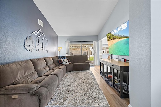 13220 February Dr, Corona, CA 92879 - living room with light wood-type flooring, lofted ceiling, and a textured wall