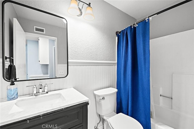 13220 February Dr, Corona, CA 92879 - bathroom featuring wainscoting, vanity, shower / tub combo, and a textured wall