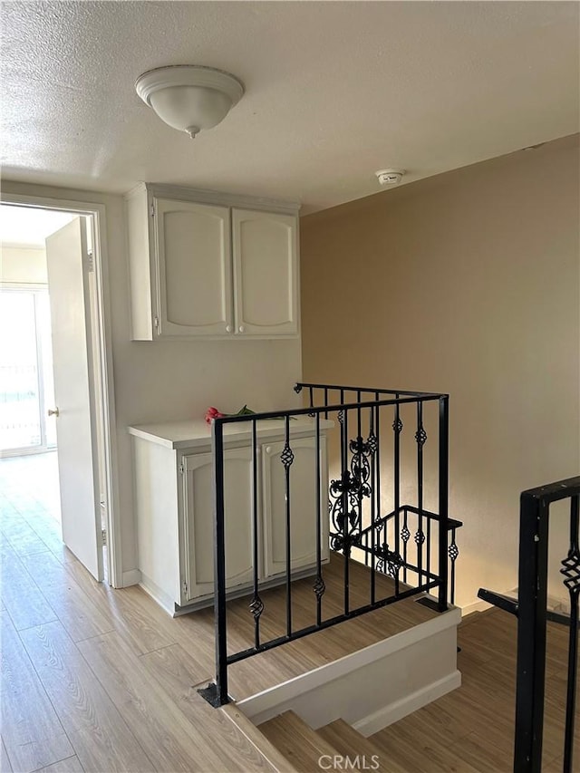 38710 10th St E Unit 12, Palmdale, CA 93550 - staircase featuring wood finished floors and a textured ceiling
