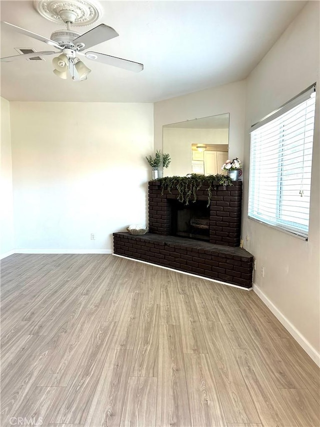 38710 10th St E Unit 12, Palmdale, CA 93550 - living area featuring wood finished floors, ceiling fan, and a brick fireplace