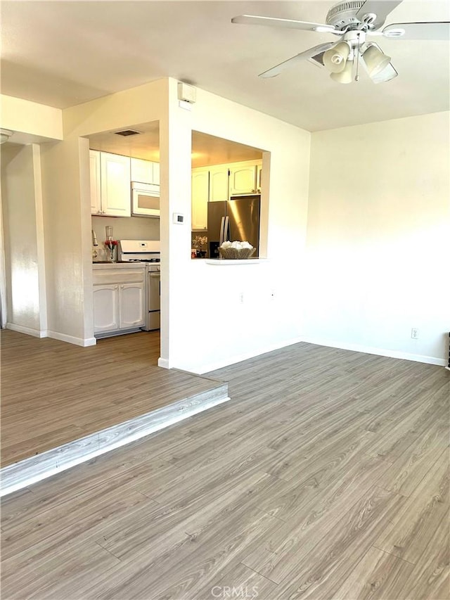 38710 10th St E Unit 12, Palmdale, CA 93550 - unfurnished living room featuring light wood-type flooring and a ceiling fan