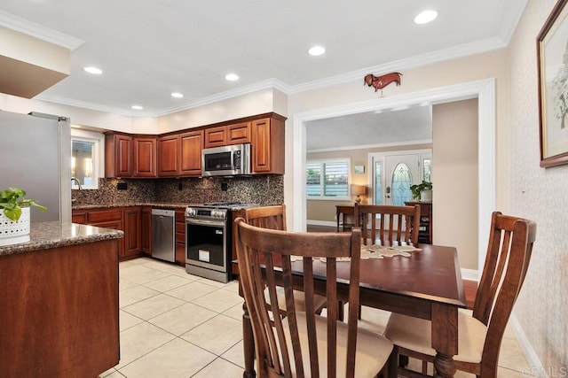 773 Puebla St, Encinitas, CA 92024 - kitchen with appliances with stainless steel finishes, light tile patterned flooring, backsplash, dark stone countertops, and ornamental molding