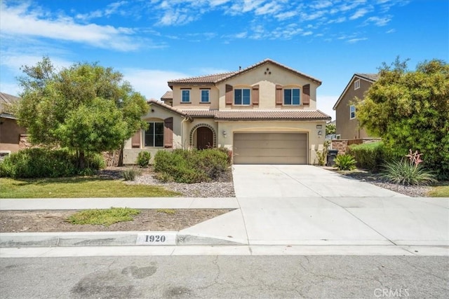 1920 Clementine St, Redlands, CA 92374 - mediterranean / spanish-style home featuring a tile roof, stucco siding, a garage, and driveway