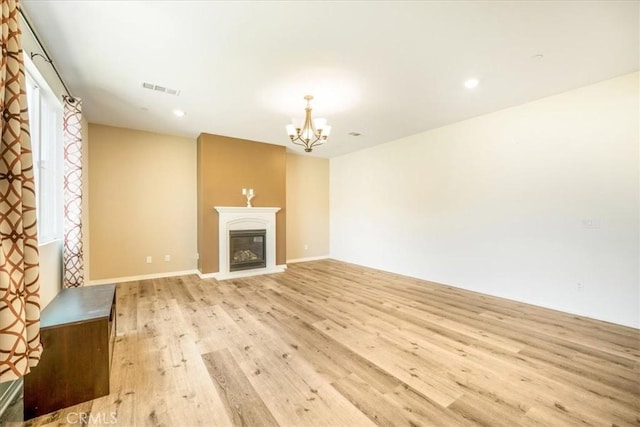 1920 Clementine St, Redlands, CA 92374 - unfurnished living room featuring light wood-style flooring, a chandelier, a glass covered fireplace, and recessed lighting