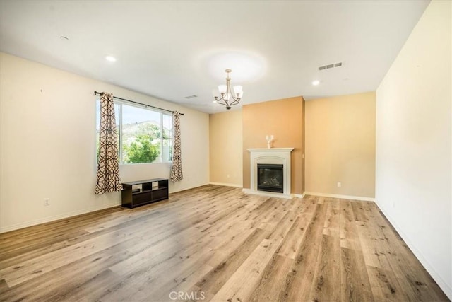 1920 Clementine St, Redlands, CA 92374 - unfurnished living room with a chandelier, wood finished floors, a glass covered fireplace, and recessed lighting
