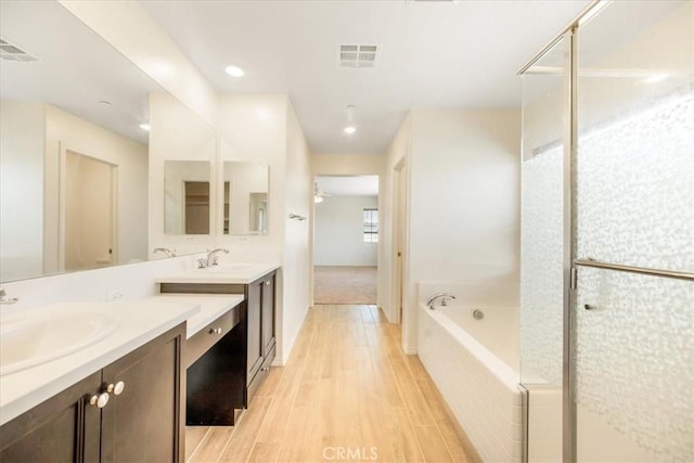 1920 Clementine St, Redlands, CA 92374 - full bath featuring vanity, a bath, wood finished floors, a stall shower, and recessed lighting