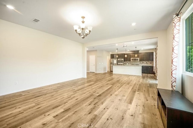 1920 Clementine St, Redlands, CA 92374 - unfurnished living room featuring a chandelier, light wood finished floors, plenty of natural light, and recessed lighting