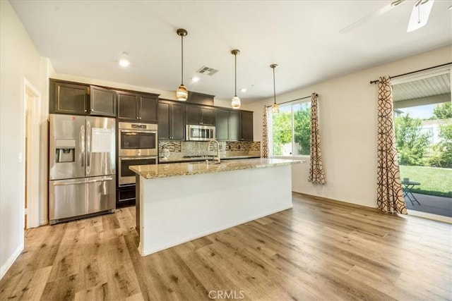 1920 Clementine St, Redlands, CA 92374 - kitchen with stainless steel appliances, light wood-style floors, a ceiling fan, backsplash, and recessed lighting