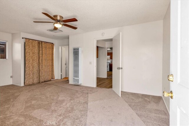 6413 Smoketree Ave Unit 29, Palms, CA 92277 - unfurnished bedroom with a heating unit, carpet flooring, a textured ceiling, ceiling fan, and a closet
