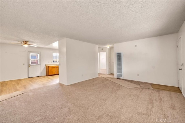 6413 Smoketree Ave Unit 29, Palms, CA 92277 - unfurnished living room featuring light carpet, a heating unit, a textured ceiling, and ceiling fan
