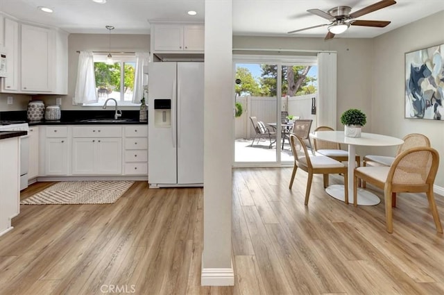 6782 Tahitian Cir, Yorba Linda, CA 92886 - kitchen with white refrigerator with ice dispenser, stove, white cabinets, light wood finished floors, and recessed lighting