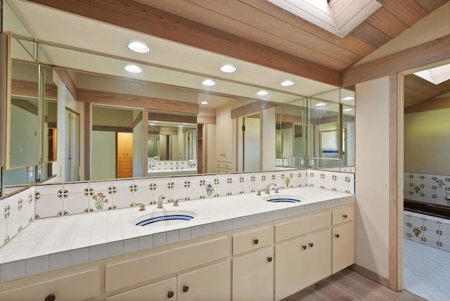 32204 Wiskon Way, Pauma Valley, CA 92061 - bathroom featuring a skylight, recessed lighting, double vanity, decorative backsplash, and vaulted ceiling