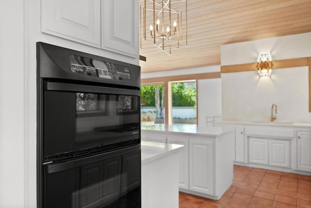 32204 Wiskon Way, Pauma Valley, CA 92061 - kitchen featuring light countertops, a chandelier, light tile patterned floors, white cabinetry, and a kitchen island