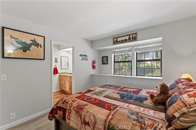 4 Village Unit 2, Lake Arrowhead, CA 92352 - bedroom featuring light wood-style floors, ensuite bathroom, and a textured ceiling