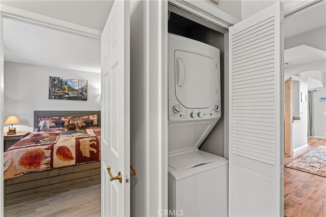 4 Village Unit 2, Lake Arrowhead, CA 92352 - laundry area featuring stacked washing machine and dryer, wood finished floors, and arched walkways