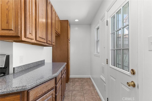 4903 Brayton Ave, Long Beach, CA 90807 - kitchen with brown cabinets, stone counters, light tile patterned flooring, and recessed lighting
