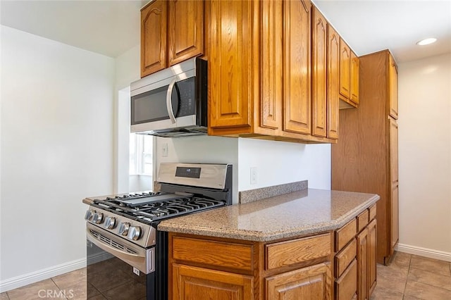 4903 Brayton Ave, Long Beach, CA 90807 - kitchen with appliances with stainless steel finishes, brown cabinetry, light stone countertops, light tile patterned floors, and recessed lighting