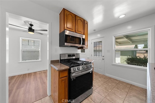4903 Brayton Ave, Long Beach, CA 90807 - kitchen featuring appliances with stainless steel finishes, brown cabinetry, a ceiling fan, and light tile patterned floors