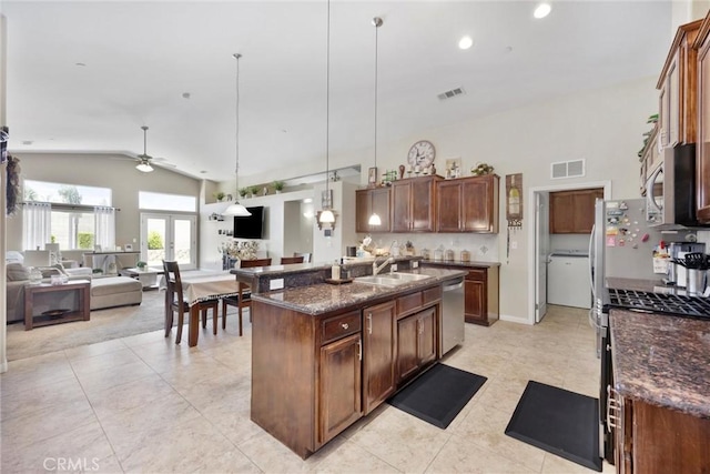 9504 Whitman Ave, Bakersfield, CA 93311 - kitchen featuring appliances with stainless steel finishes, a ceiling fan, open floor plan, light tile patterned floors, and dark stone countertops