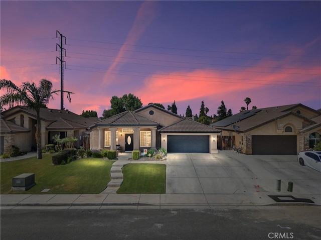 9504 Whitman Ave, Bakersfield, CA 93311 - view of front of house with an attached garage, driveway, a tiled roof, stucco siding, and a front yard