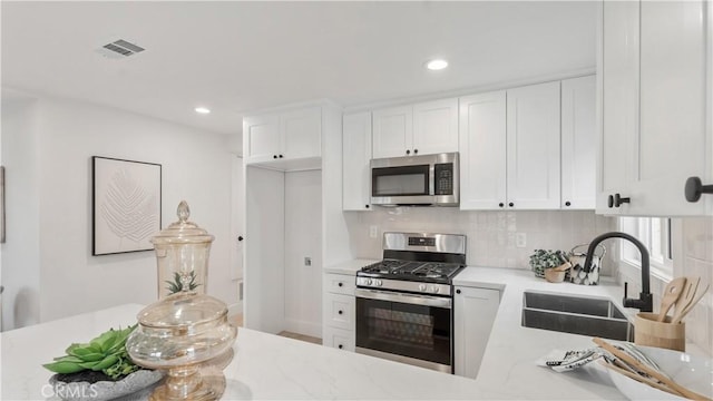 802 S Olive Ave, Alhambra, CA 91803 - kitchen with appliances with stainless steel finishes, white cabinetry, tasteful backsplash, recessed lighting, and light stone counters