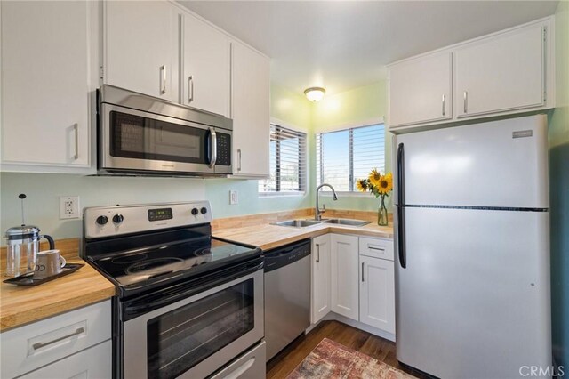 460 Golden Ave Unit 434, Long Beach, CA 90802 - kitchen with appliances with stainless steel finishes, wooden counters, dark wood-type flooring, and white cabinetry