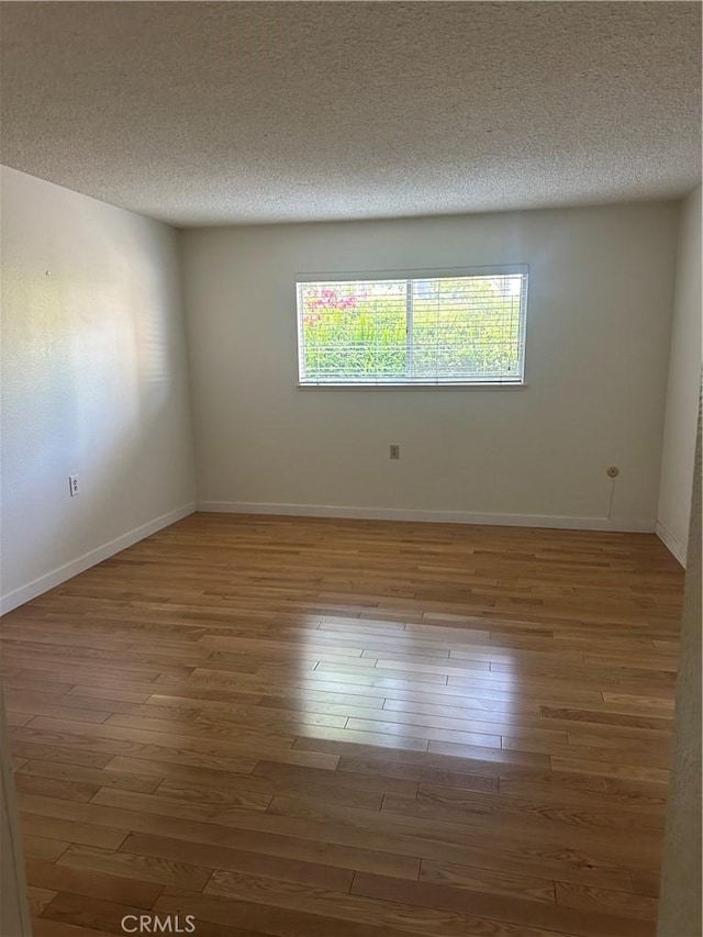 967 Calle Aragon Unit B, Laguna Woods, CA 92637 - empty room with wood finished floors and a textured ceiling